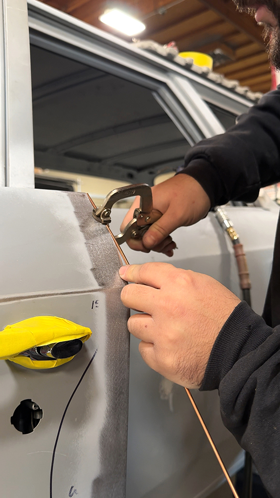 004 Copper strip securely clamped to the door gap for alignment before welding