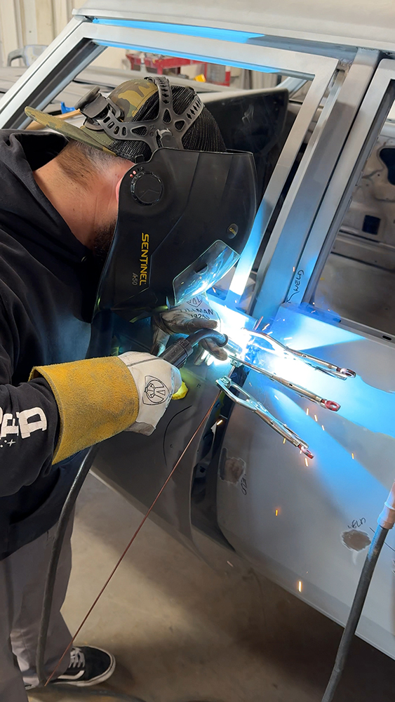 005 Technician welding gaps wearing protective gear sparks flying during the process