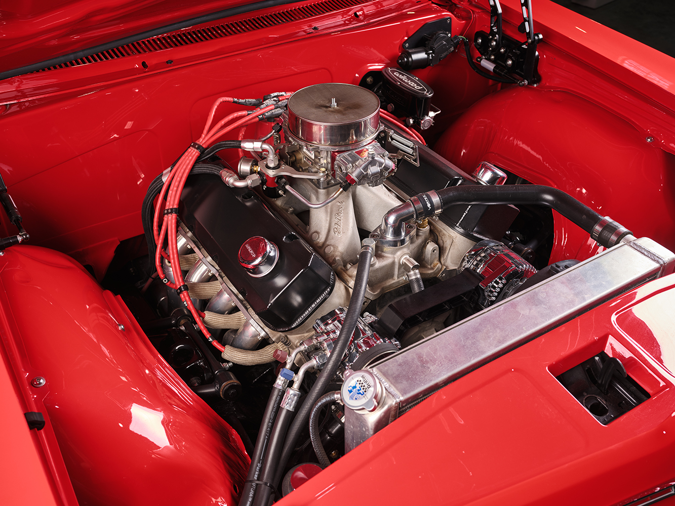 006 1965 Chevrolet Impala SS engine bay featuring a high performance V8 engine red accents and custom modifications