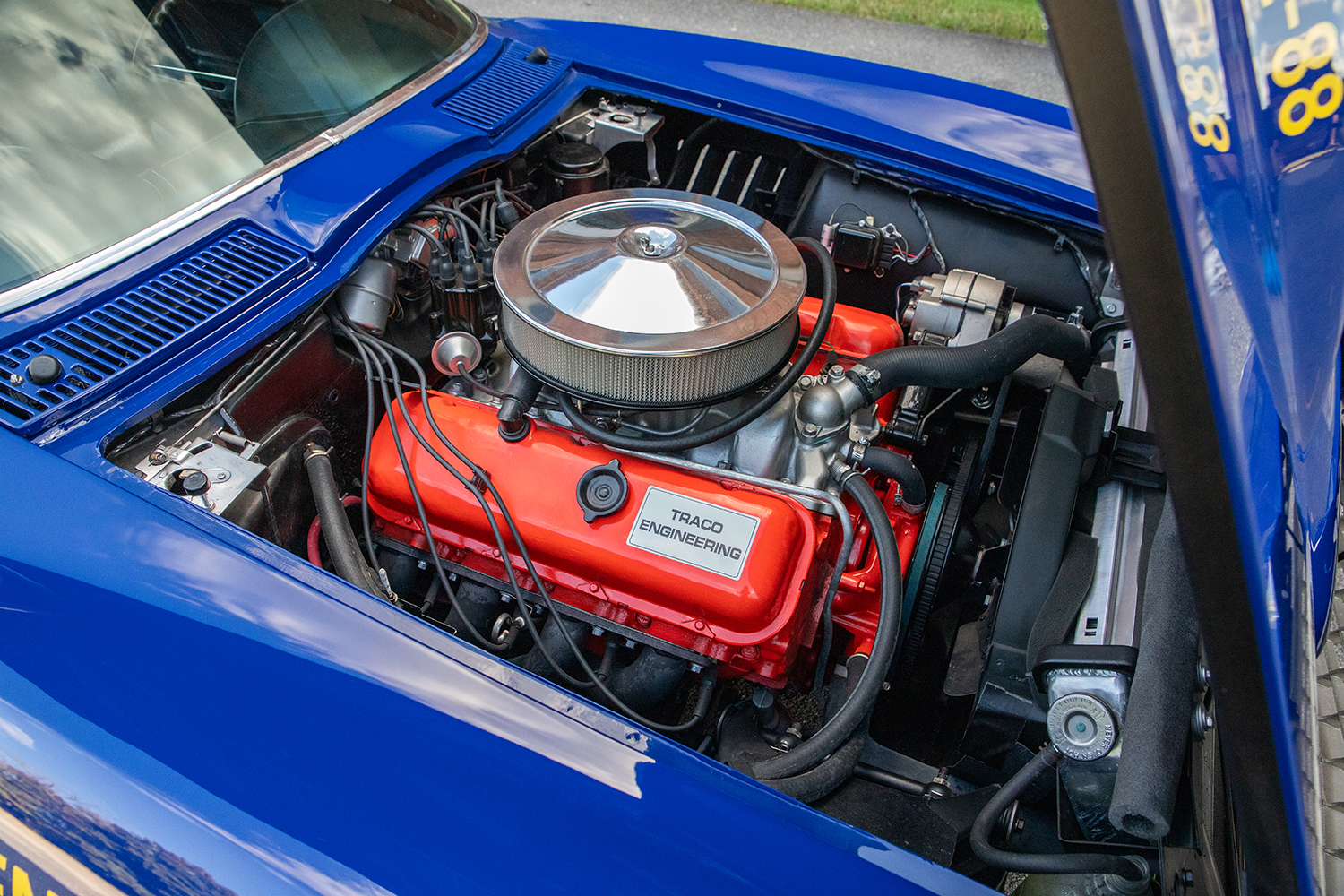 007 1966 Chevrolet Corvette close up of Traco Engineering valve cover emphasizing precision and bright red engine block