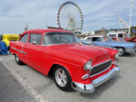 009 1955 Chevy 210 in vibrant red with smoothed bumpers and retro style wheels at the fairground lot