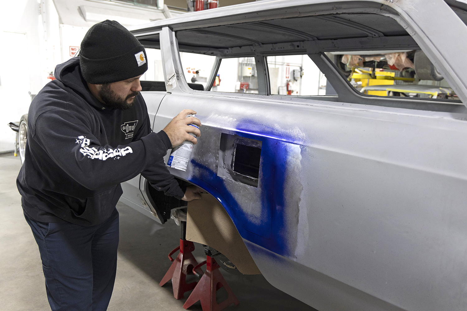009 Technician sprays layout fluid on the fuel door opening to mark precise cuts for a clean installation