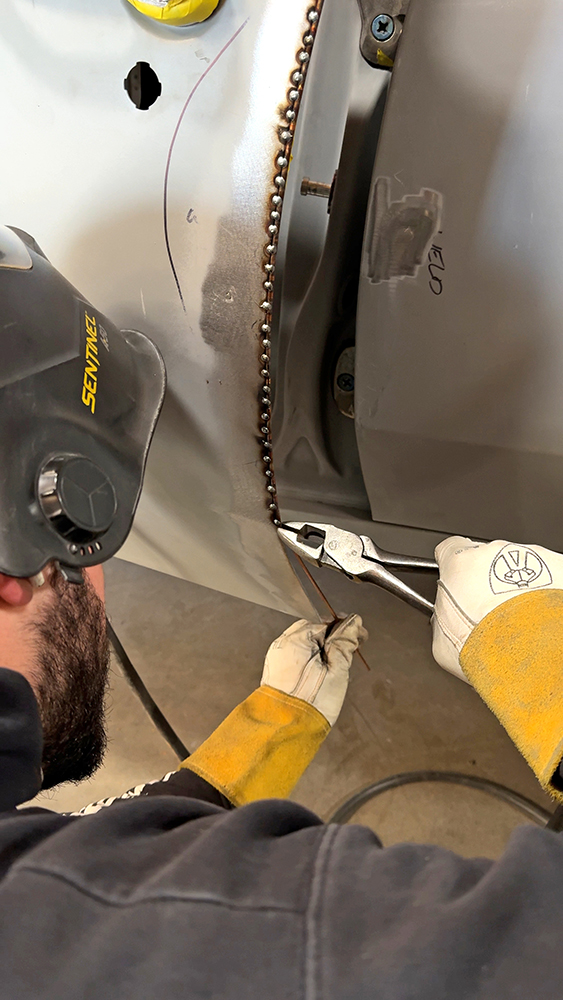 009 Worker welding door gap with copper strip and clamps in place for accuracy