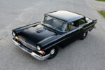 01 1957 Ford Custom with deep black paint hood scoop and chrome bumper captured from a high angle