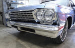 01 A restored 1962 Chevy Impala with a gleaming chrome grille and quad headlight design