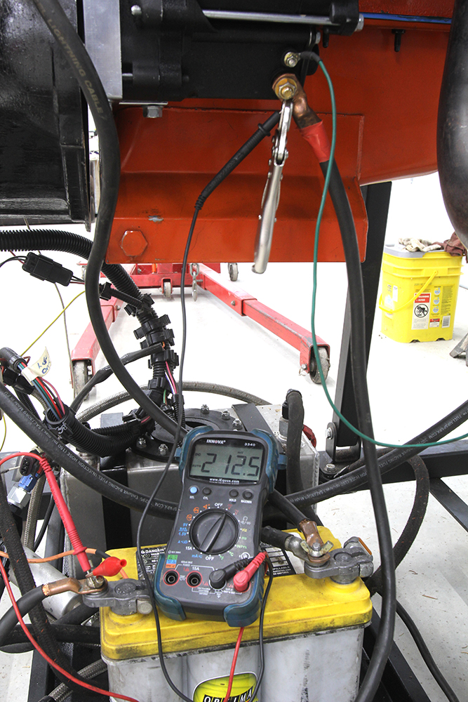 010 Multimeter measuring battery voltage (21 25V) during starter engagement on a mounted engine
