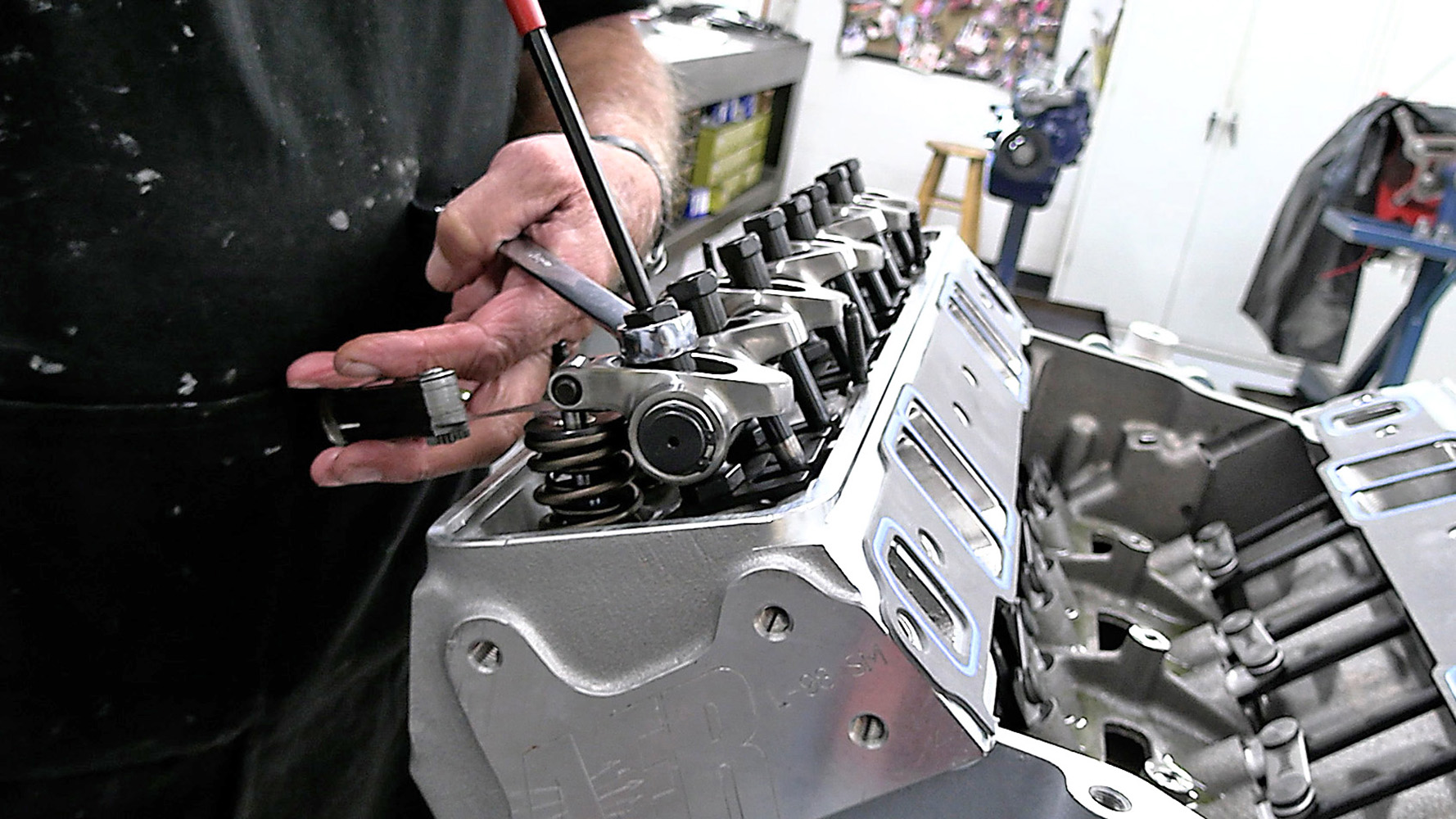 010 Technician fine tuning rocker arm clearances on a fully assembled cylinder head