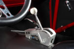 012 1957 Chevrolet Bel Air Hurst shifter with a white ball knob and ratchet style mechanism mounted in a custom aluminum housing