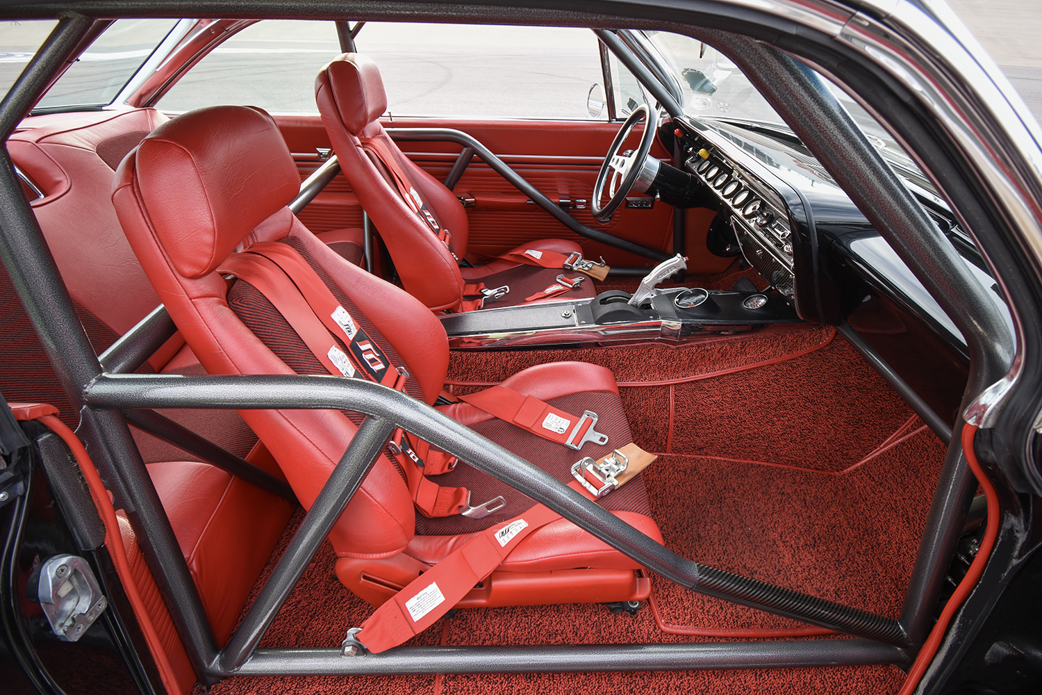012 1961 Chevrolet Impala racing interior with red bucket seats roll cage and Simpson harnesses for safety and performance