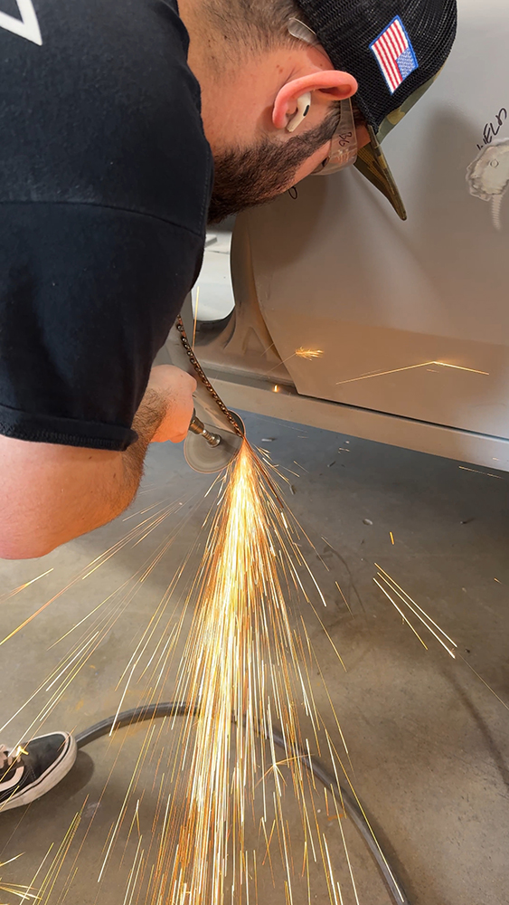 012 Technician grinding weld seams on the lower door panel sparks flying