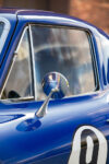 013 1966 Chevrolet Corvette side mirror detail chrome finish with reflections enhancing the sleek blue body