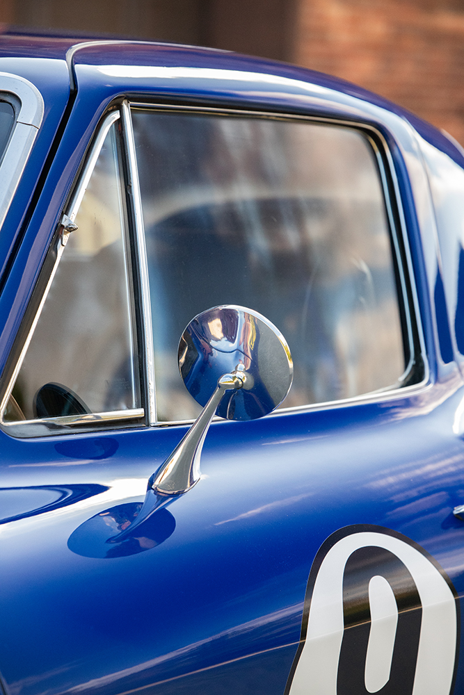 013 1966 Chevrolet Corvette side mirror detail chrome finish with reflections enhancing the sleek blue body