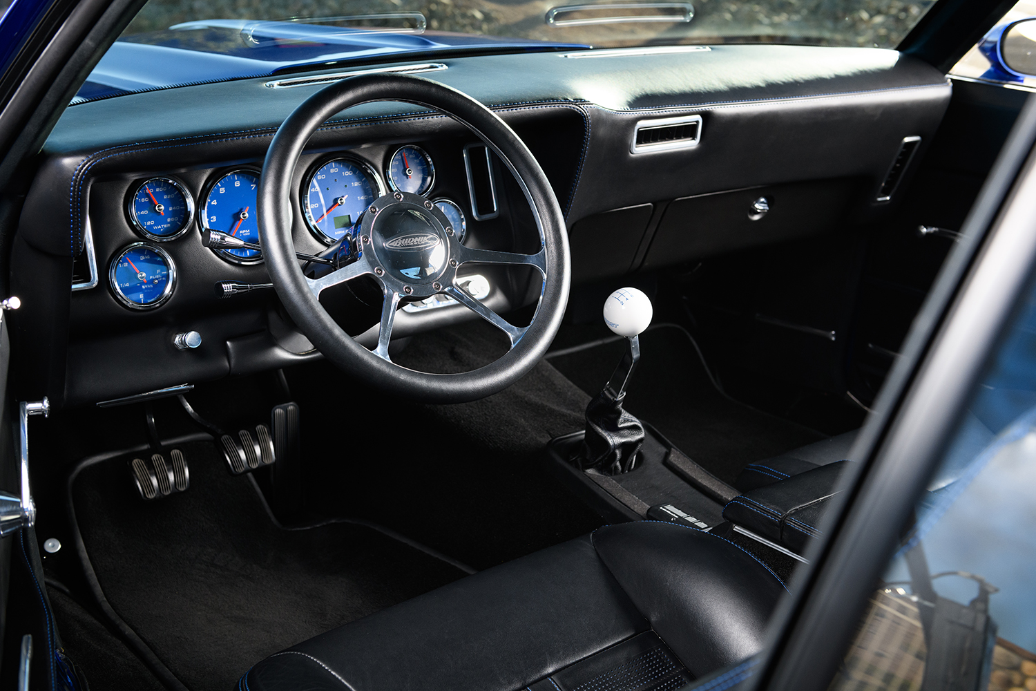 013 1969 Chevrolet Camaro interior with modern gauges custom steering wheel and a classic white Hurst shifter
