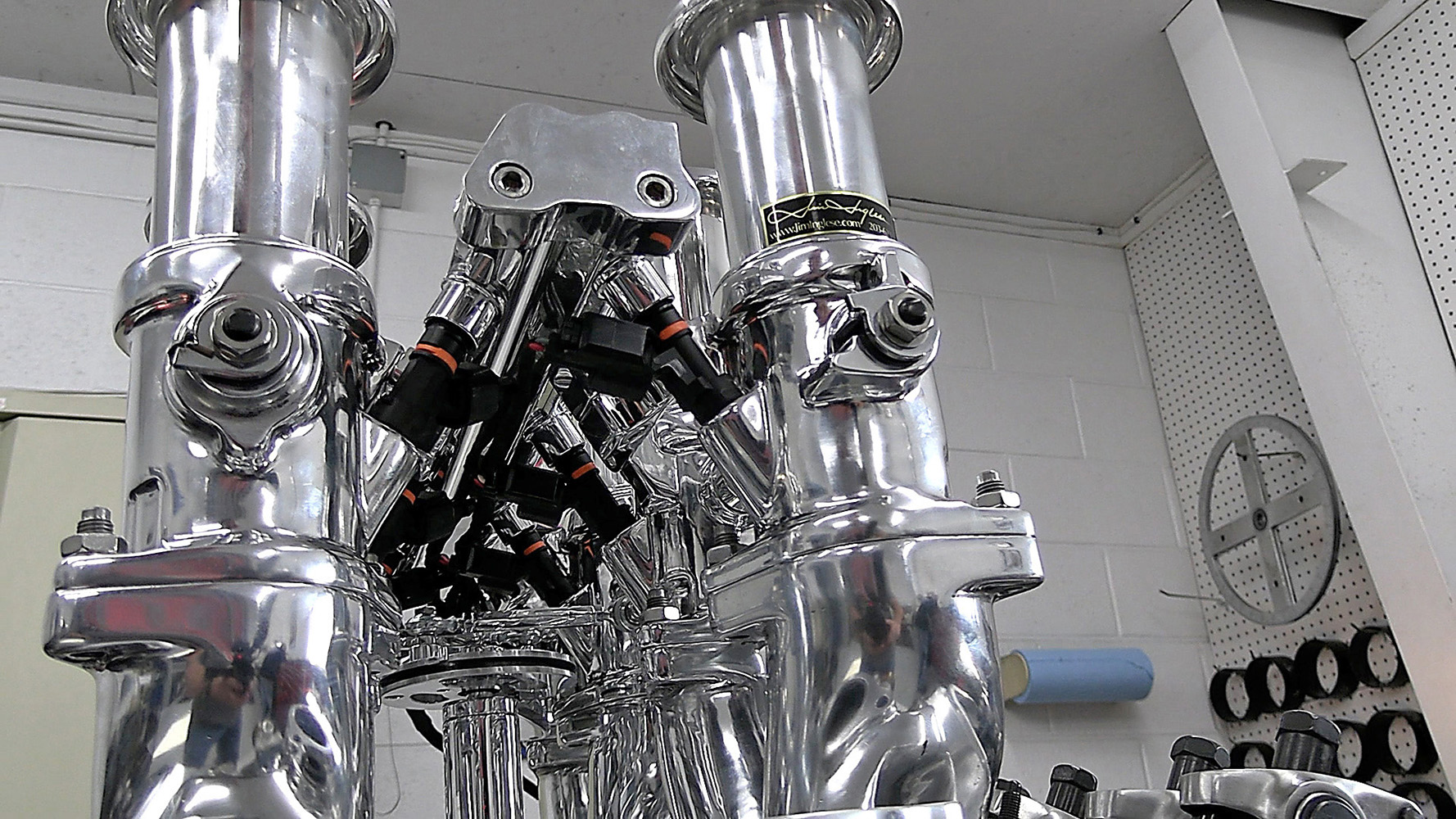 013 Close up of polished throttle bodies with integrated fuel injectors and connectors