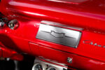 014 1957 Chevrolet Bel Air glovebox door with a custom Chevrolet emblem on a red painted classic dashboard