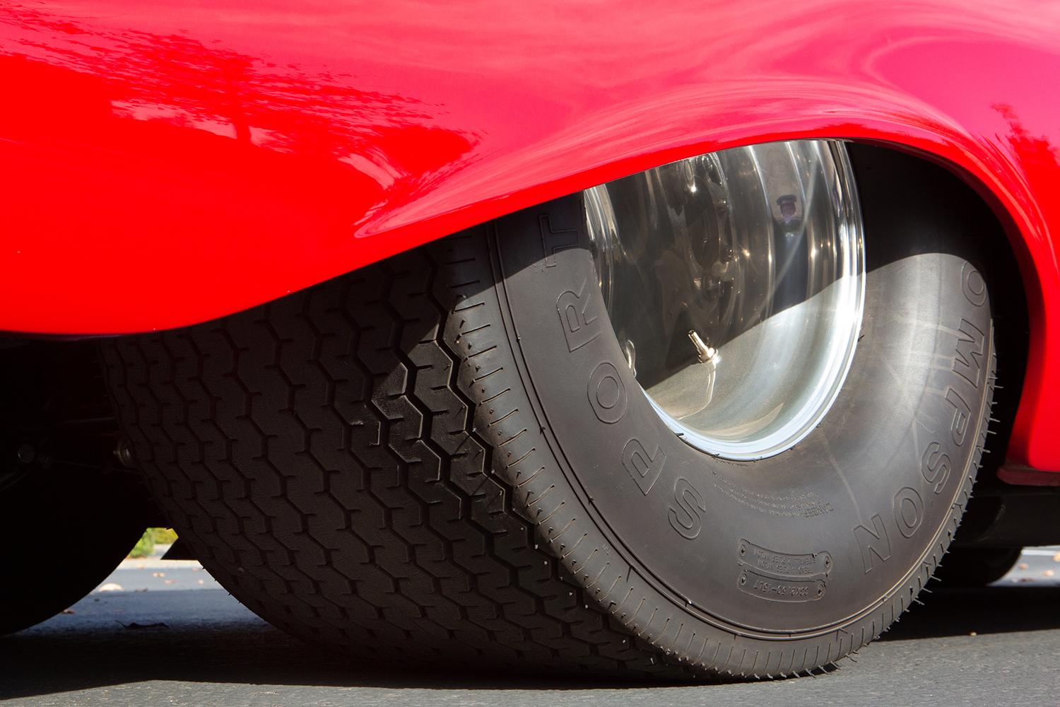 016 1957 Chevrolet Bel Air rear wheels with massive drag tires and polished deep dish rims tucked under the fender