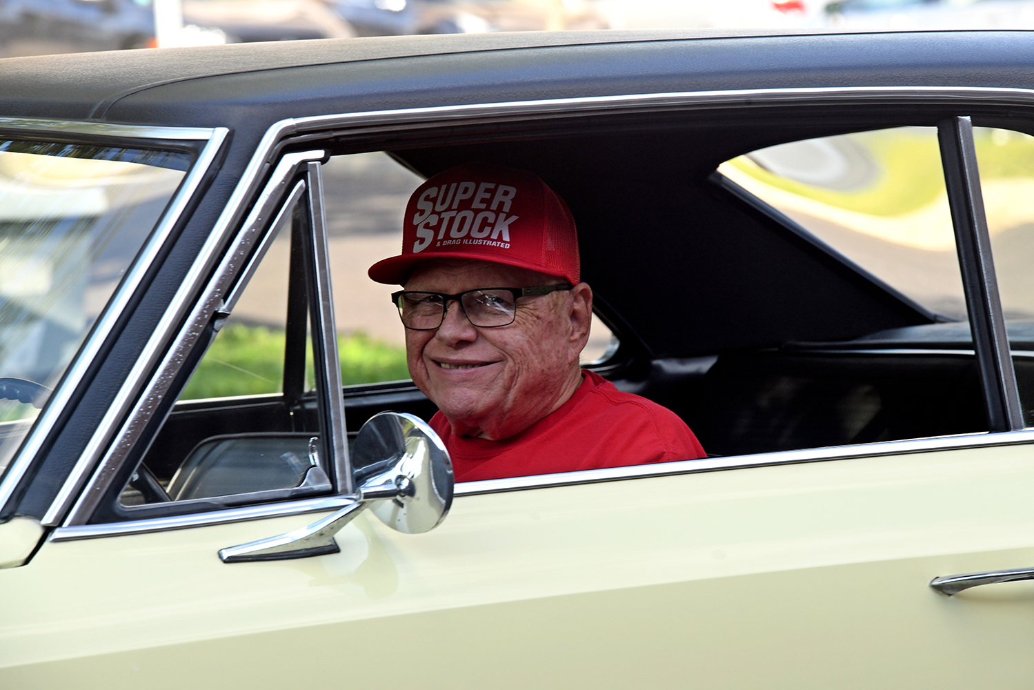 016 1967 Chevrolet Nova SS with smiling driver in Super Stock hat adding a personal touch to the classic car