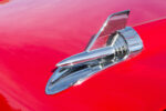 017 1957 Chevrolet Bel Air hood ornament featuring the iconic chrome jet design on a glossy red finish