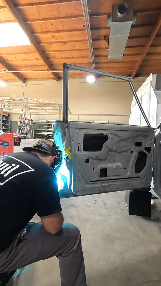 018 Technician welding the inner door panel ensuring structural integrity