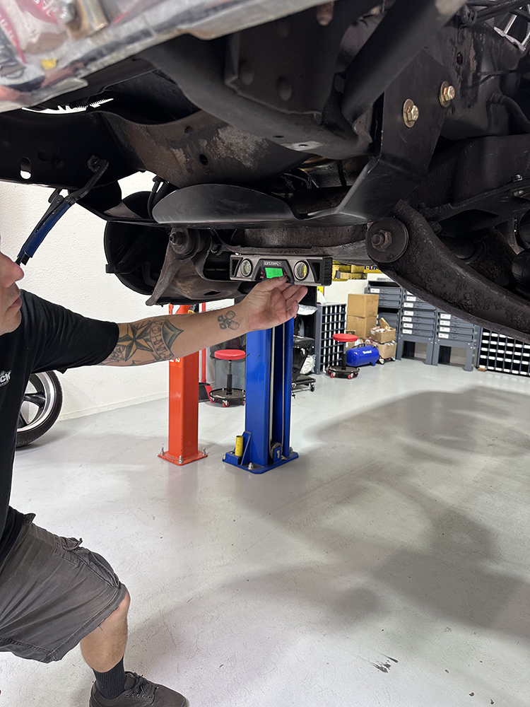 06 Leveling the new steering rack bracket to ensure proper alignment before bolting
