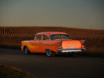 07 1957 Chevrolet Bel Air rear view showing its iconic tail fins and chrome bumper under golden evening light