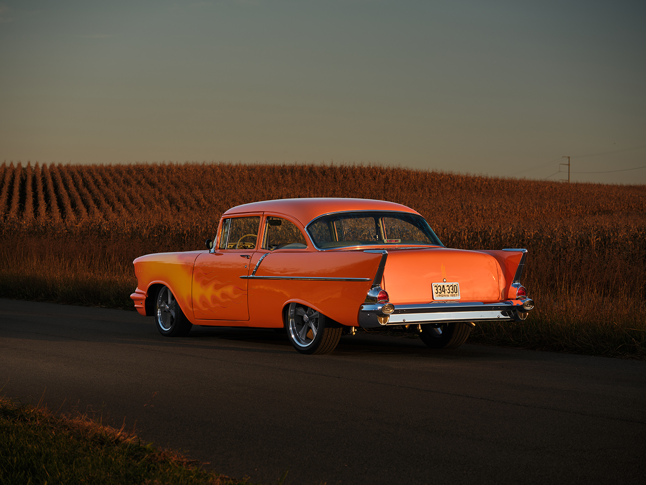 07 1957 Chevrolet Bel Air rear view showing its iconic tail fins and chrome bumper under golden evening light
