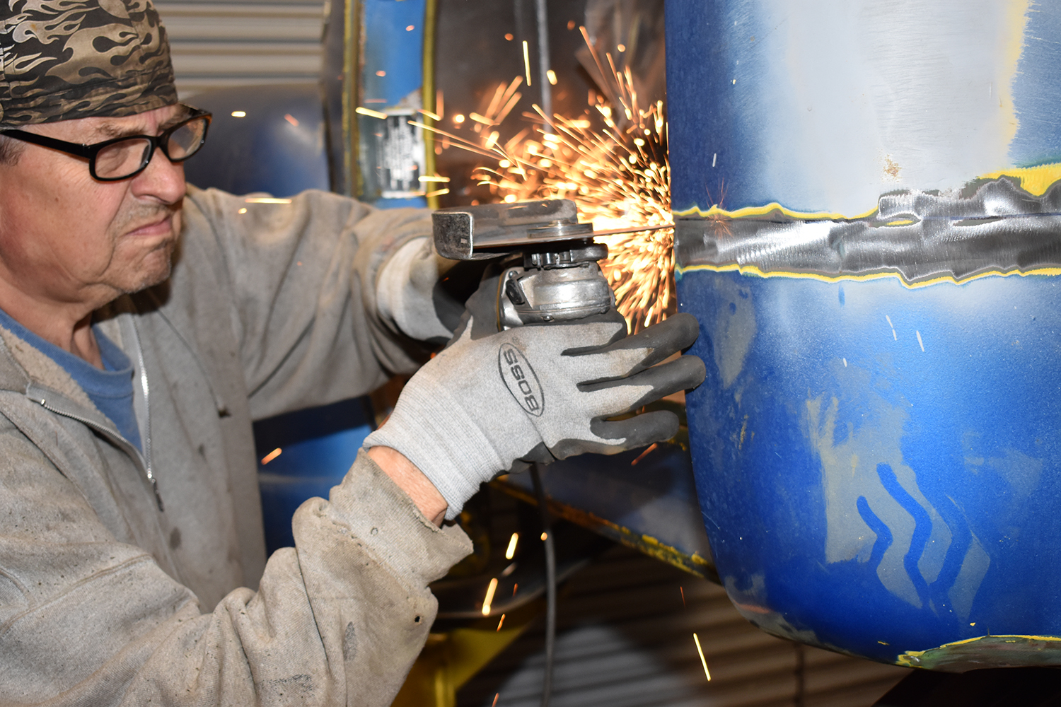 10 A fabricator using an angle grinder to smooth the welded seam on a truck cab corner