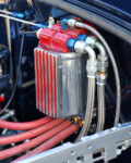 11 1932 Ford Tudor close up of the red and polished oil filter system with braided lines