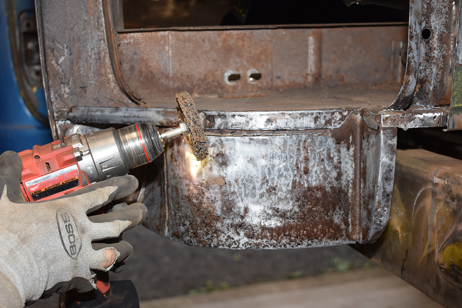 13 Cleaning and preparing the inner cab structure with a drill and abrasive disc