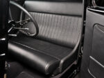 14 1933 Ford Five Window Coupe interior with a sleek black leather bench seat and minimalist styling