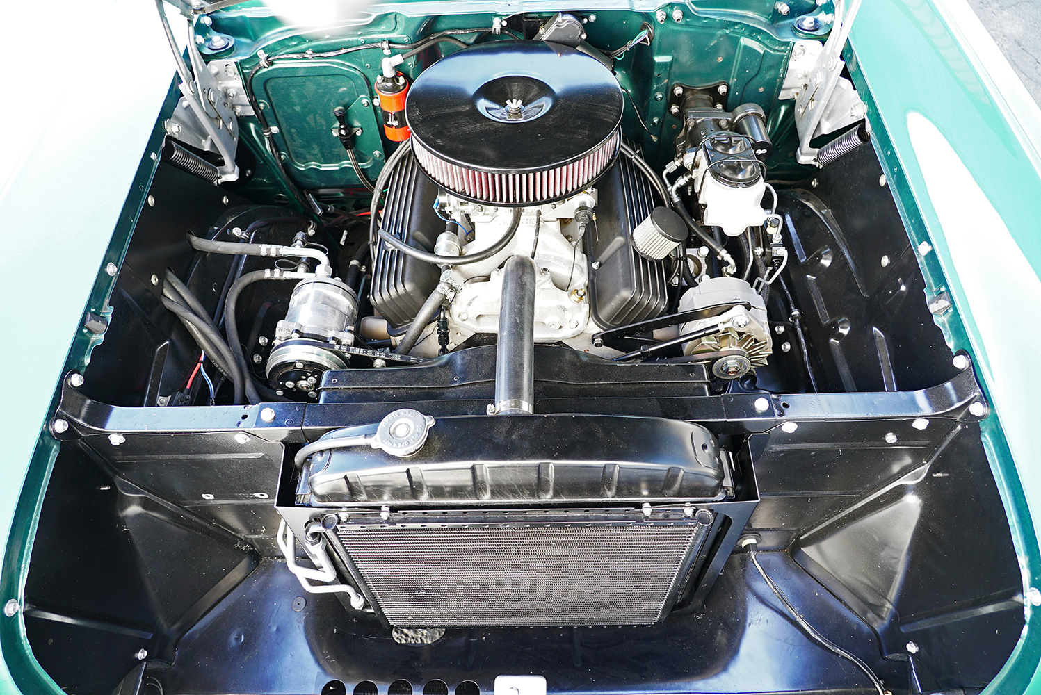 14 Engine bay of a classic car featuring a Vintage Air AC system with a polished compressor and black condenser