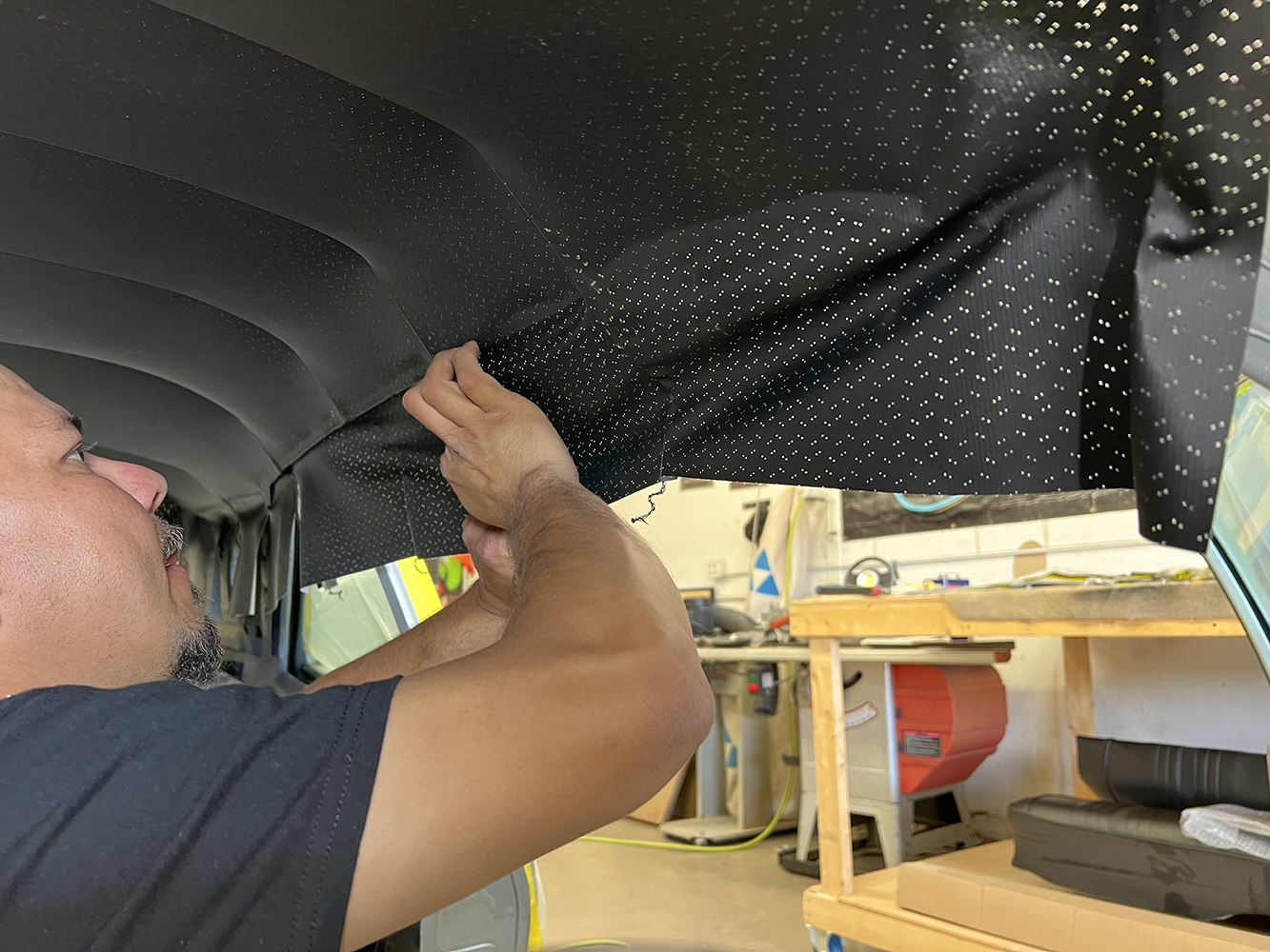 16 Worker stretching and fitting the headliner for a clean finish in a 1970 Chevy Nova