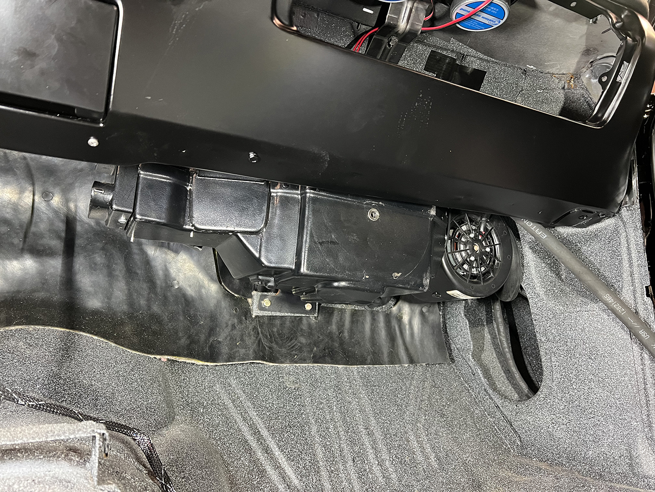 17 Mounted Vintage Air evaporator unit under the dashboard of a classic car secured with black brackets