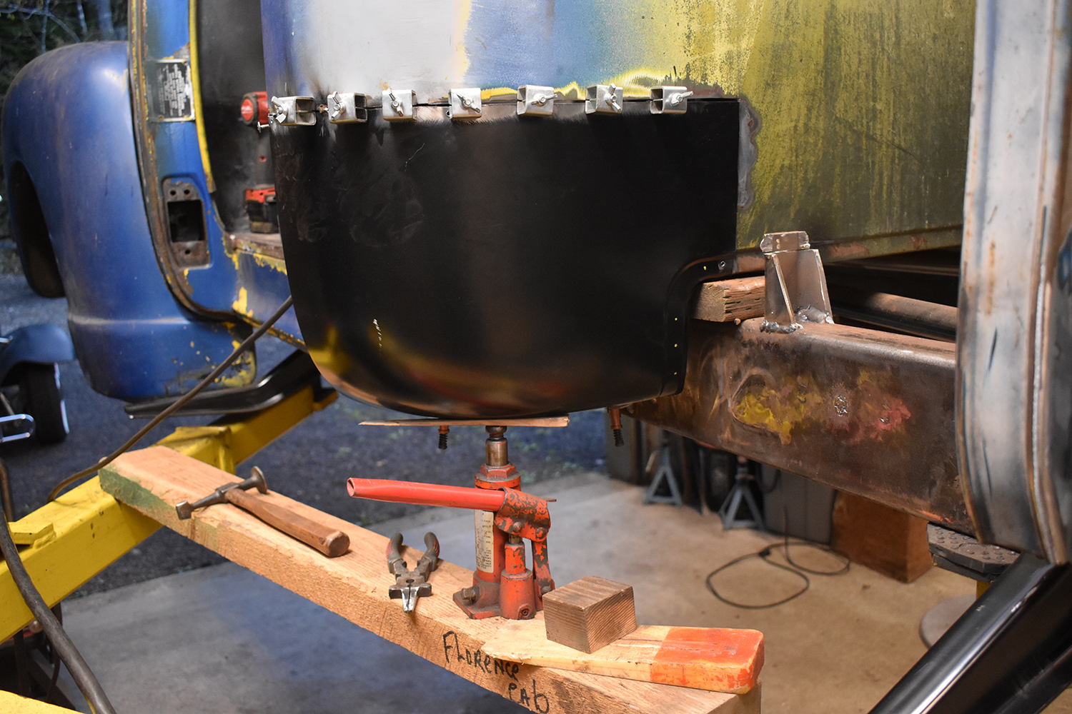 17 Replacement cab corner clamped in place supported by a hydraulic jack