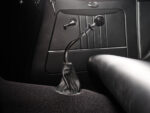 18 1933 Ford Five Window Coupe shifter with a black knob and leather boot on a clean black carpeted floor