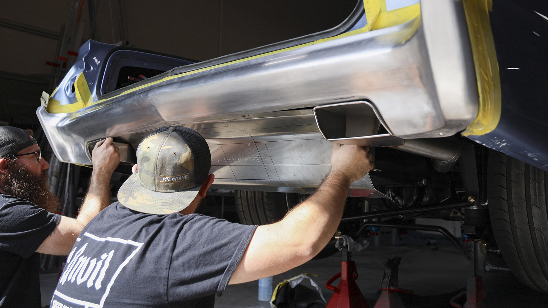 18 Two fabricators installing a custom rear lower valance on a 1962 Chevy Impala