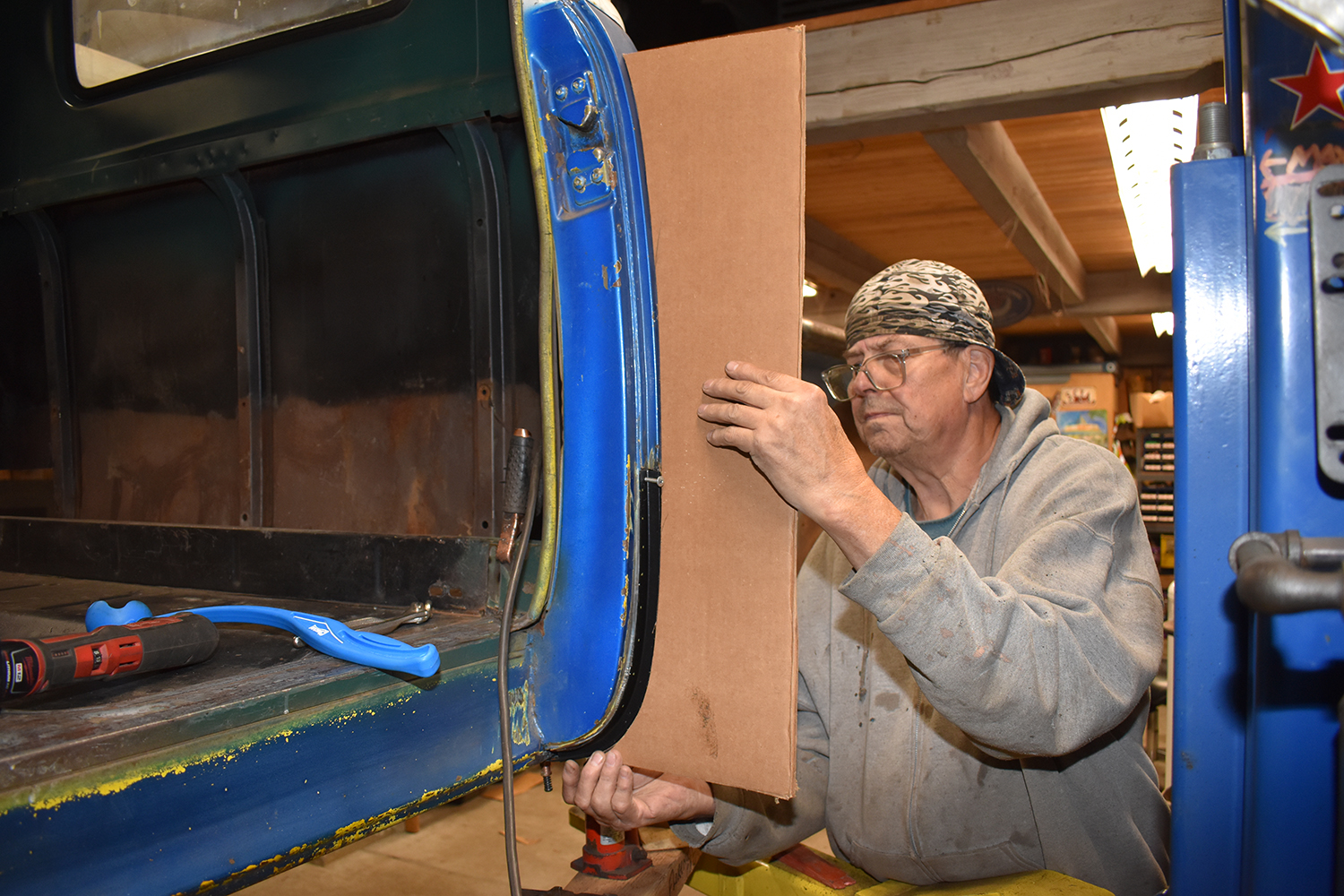 19 Aligning a cardboard template against the truck cab for precise metal fabrication