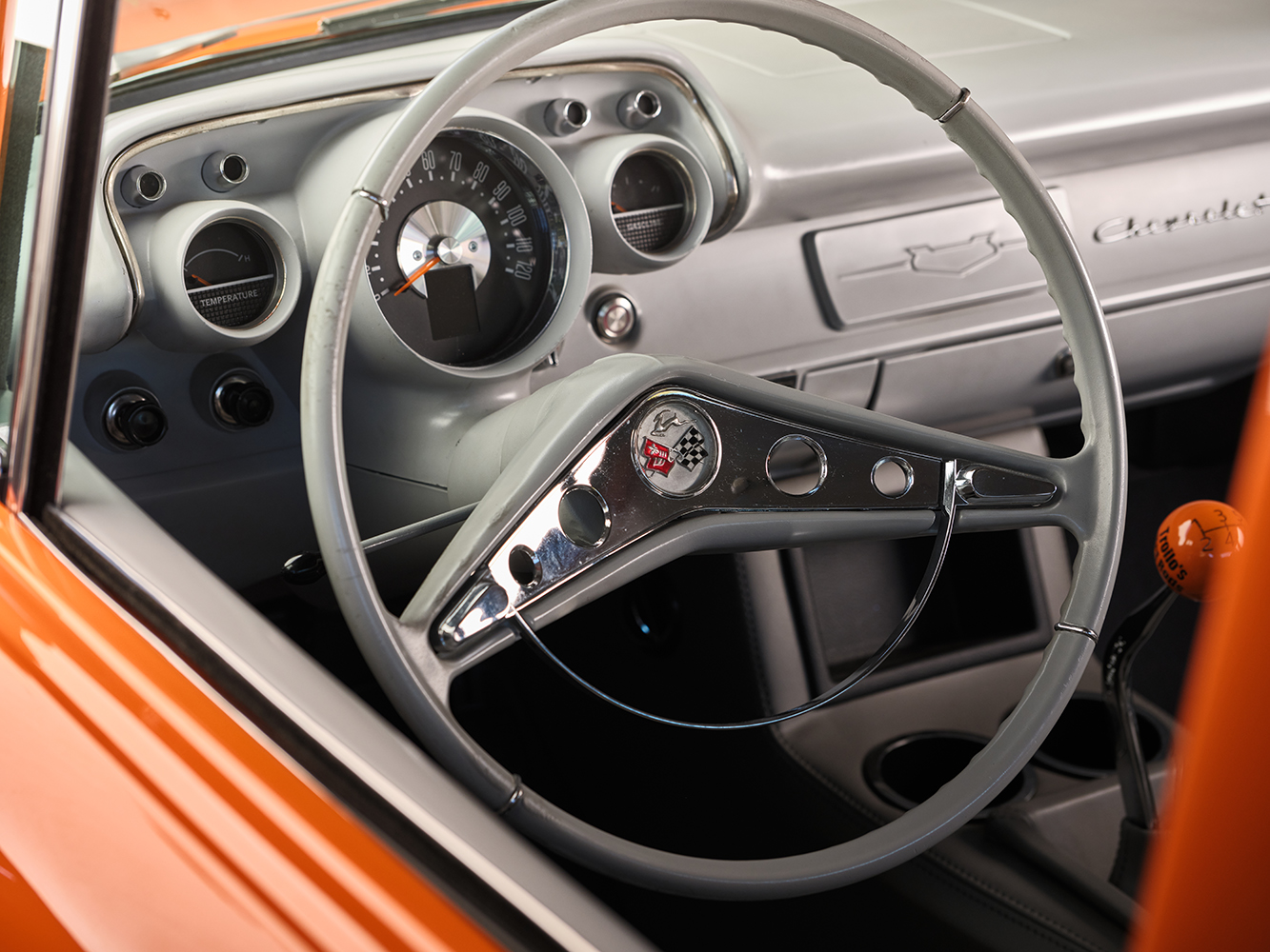 21 1957 Chevrolet Bel Air featuring a classic chrome rimmed steering wheel with Corvette emblem and a retro modern dash