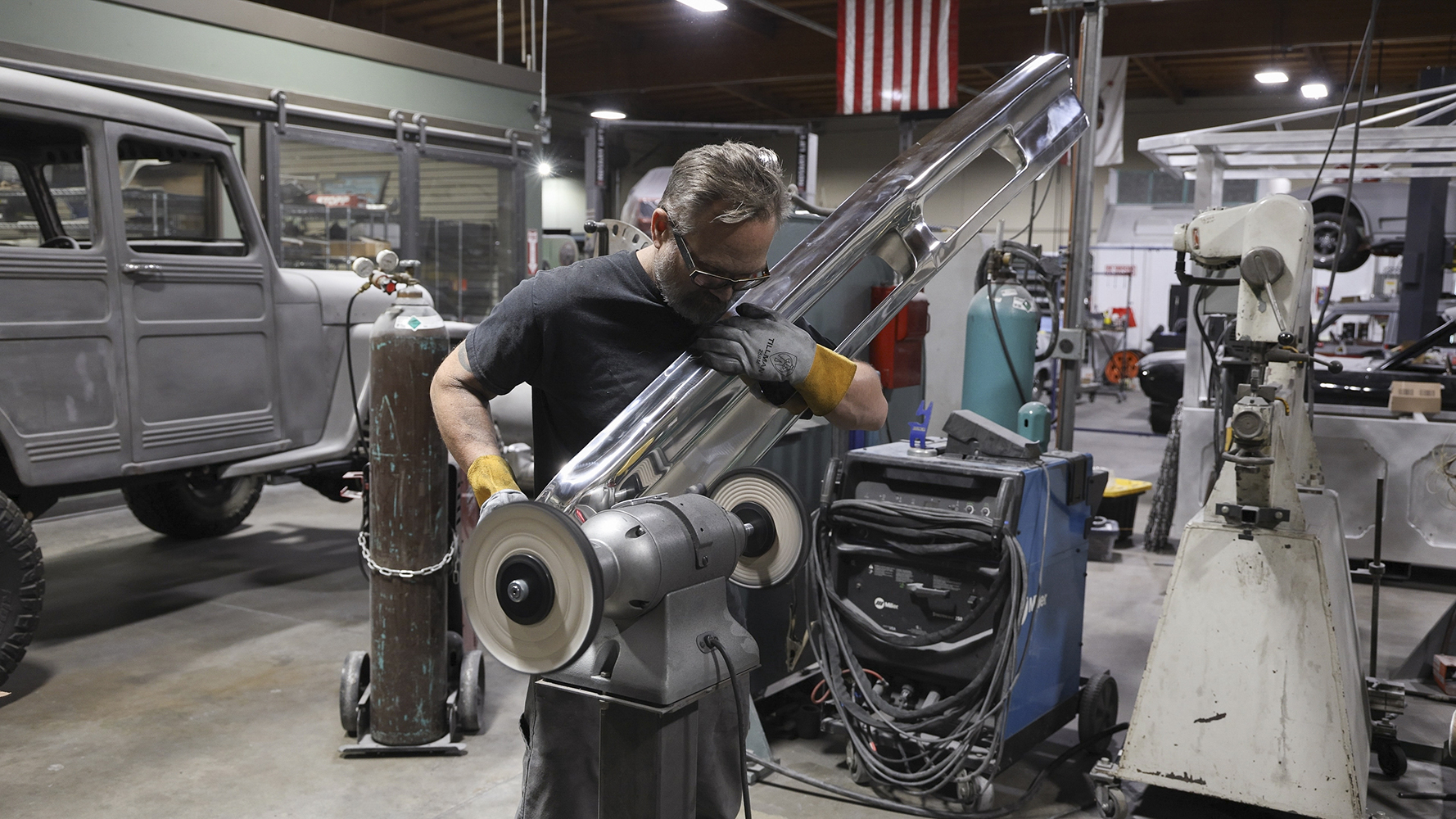 22 A fabricator meticulously buffing a custom fabricated bumper for a 1962 Chevy Impala to a mirror shine