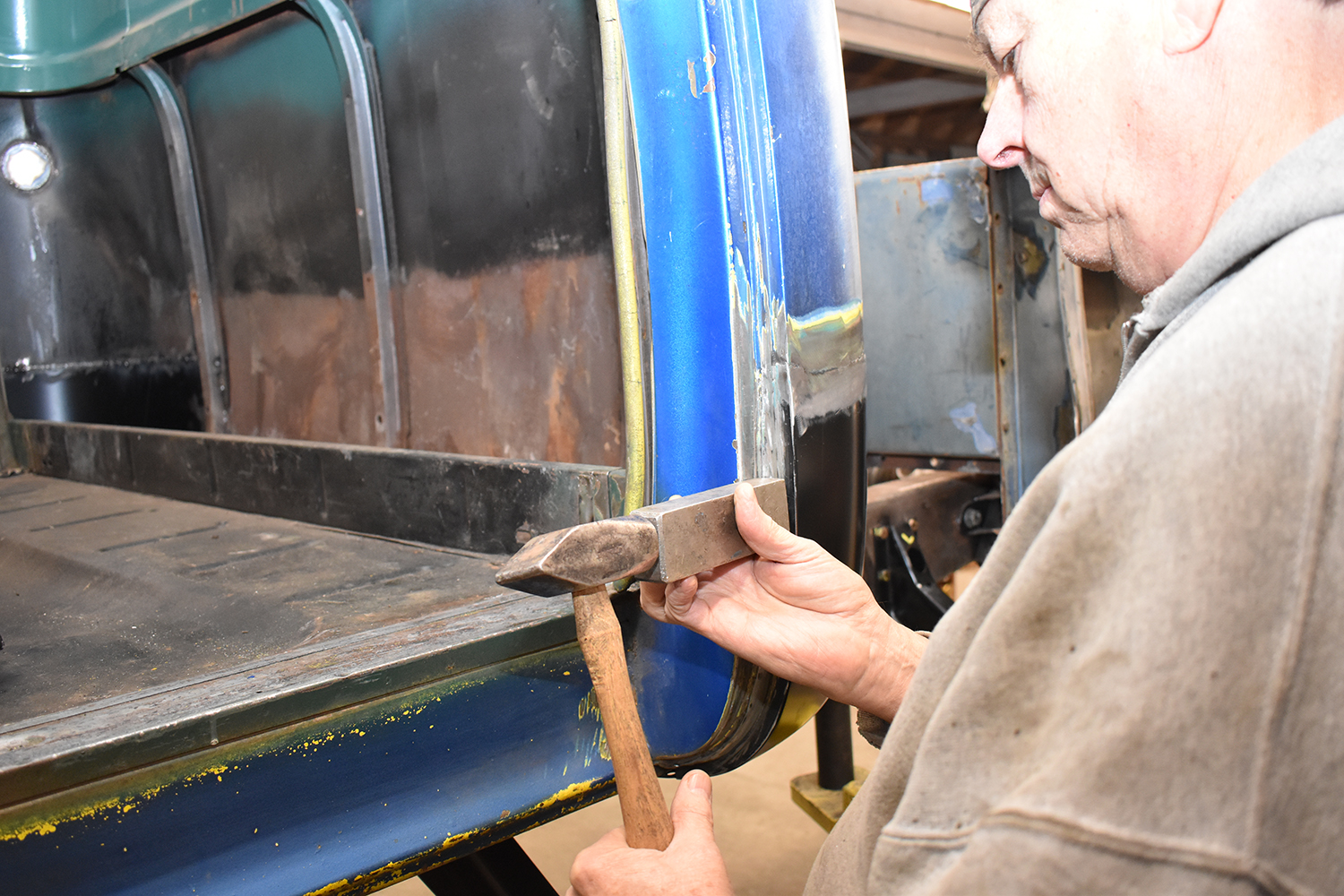 24 Metalworking hammer and dolly being used to refine the door pillar shape