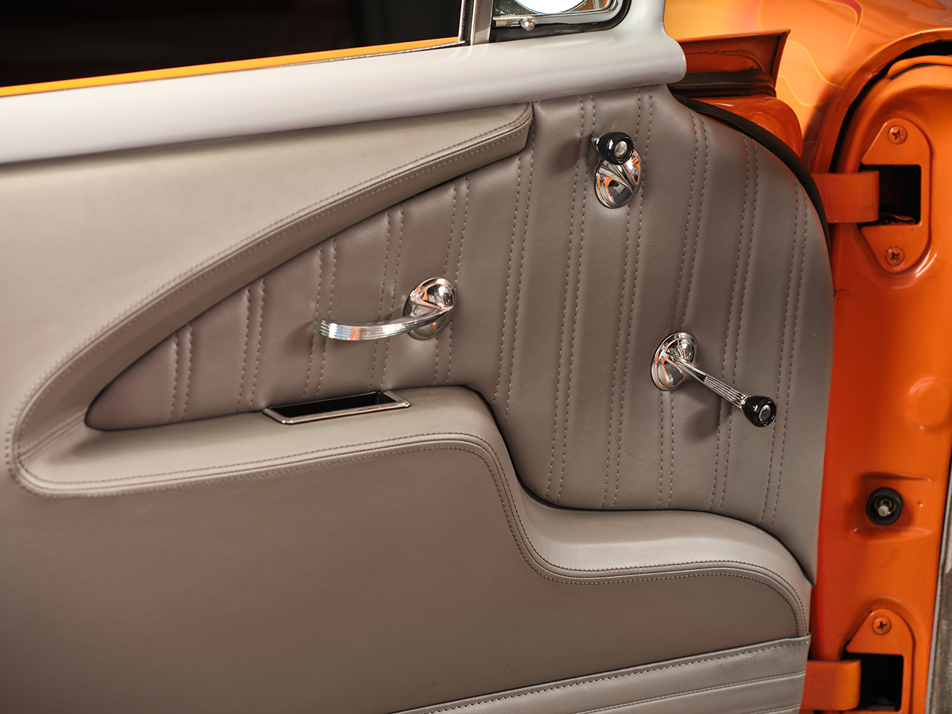 28 1957 Chevrolet Bel Air door panel with custom stitched leather polished handles and a retro modern aesthetic