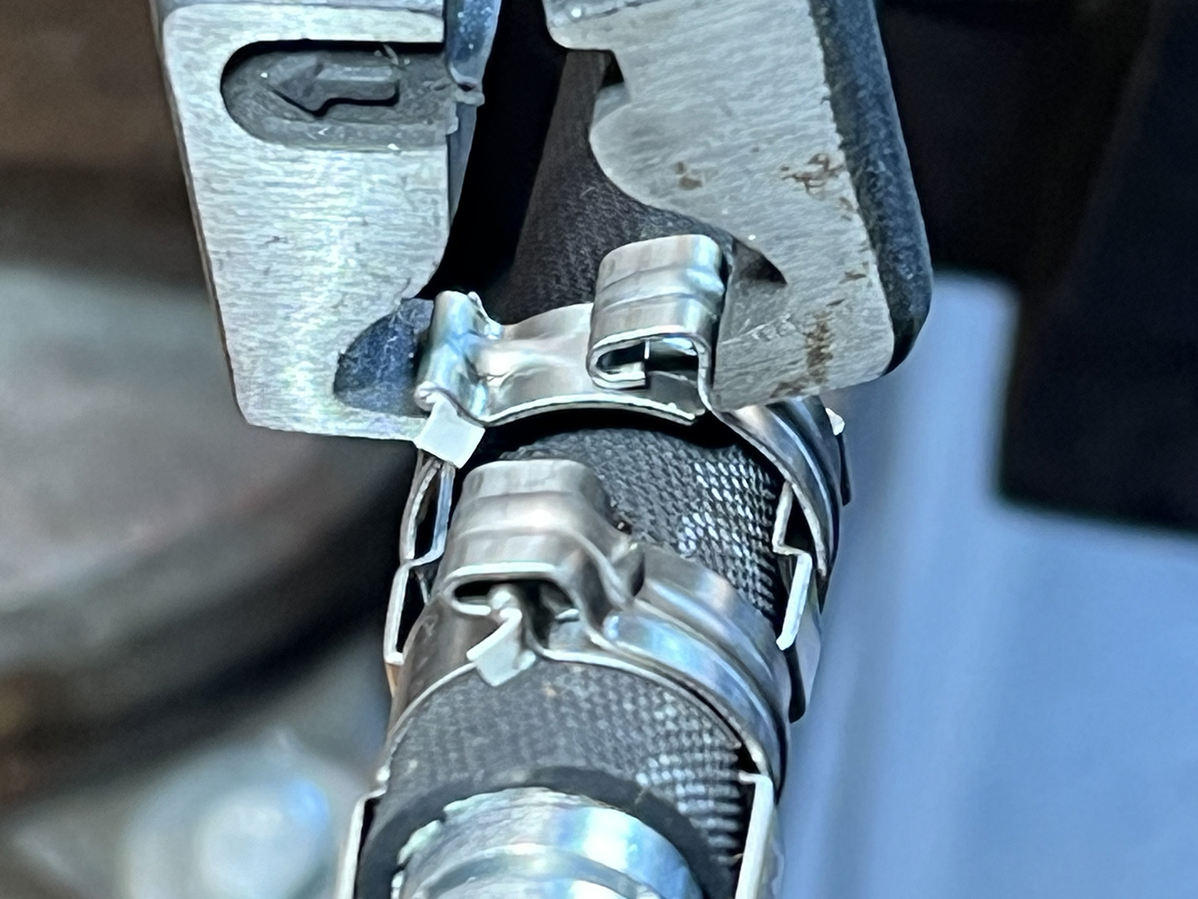 29 Crimping tool applying metal clamps to an AC hose fitting for a tight seal