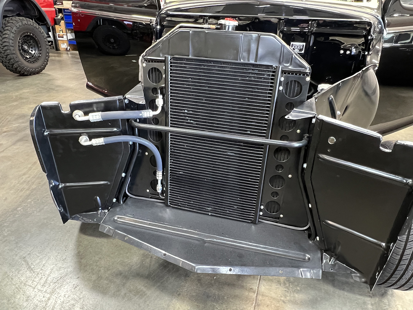 33 vintage car s front end with a mounted AC condenser and routed refrigerant lines