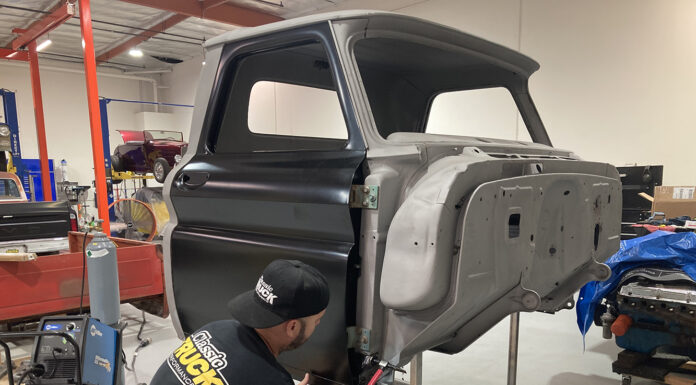 00 Classic truck cab undergoing rocker panel replacement in a restoration shop