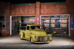 01 1952 Chevrolet 3100 parked at a vintage gas station with a sleek olive green paint job and chrome grille