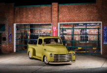 01 1952 Chevrolet 3100 parked at a vintage gas station with a sleek olive green paint job and chrome grille