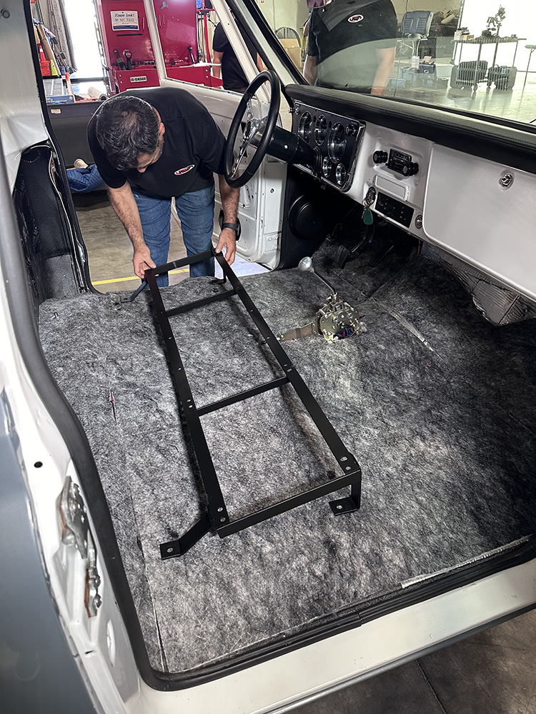 03 Technician positioning seat bracket inside truck’s insulated cab