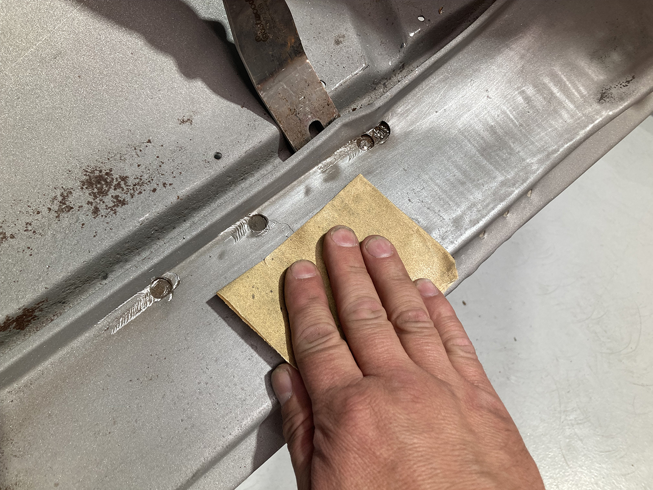 04 Sanding down welds for a smooth surface before new panel installation