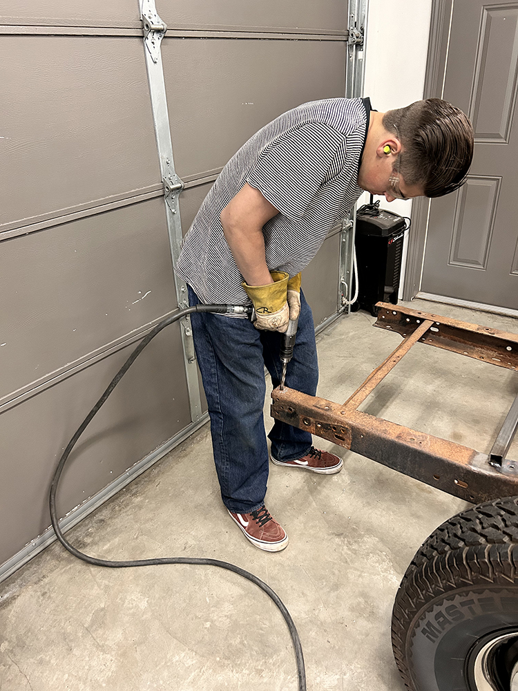 05 Using an air chisel to remove old rivets from the chassis