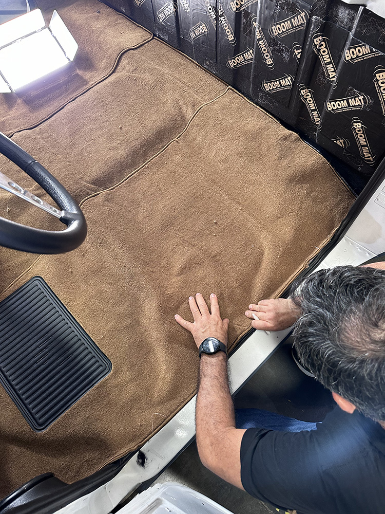 07 Black kick panel being adjusted beneath dashboard over new carpet